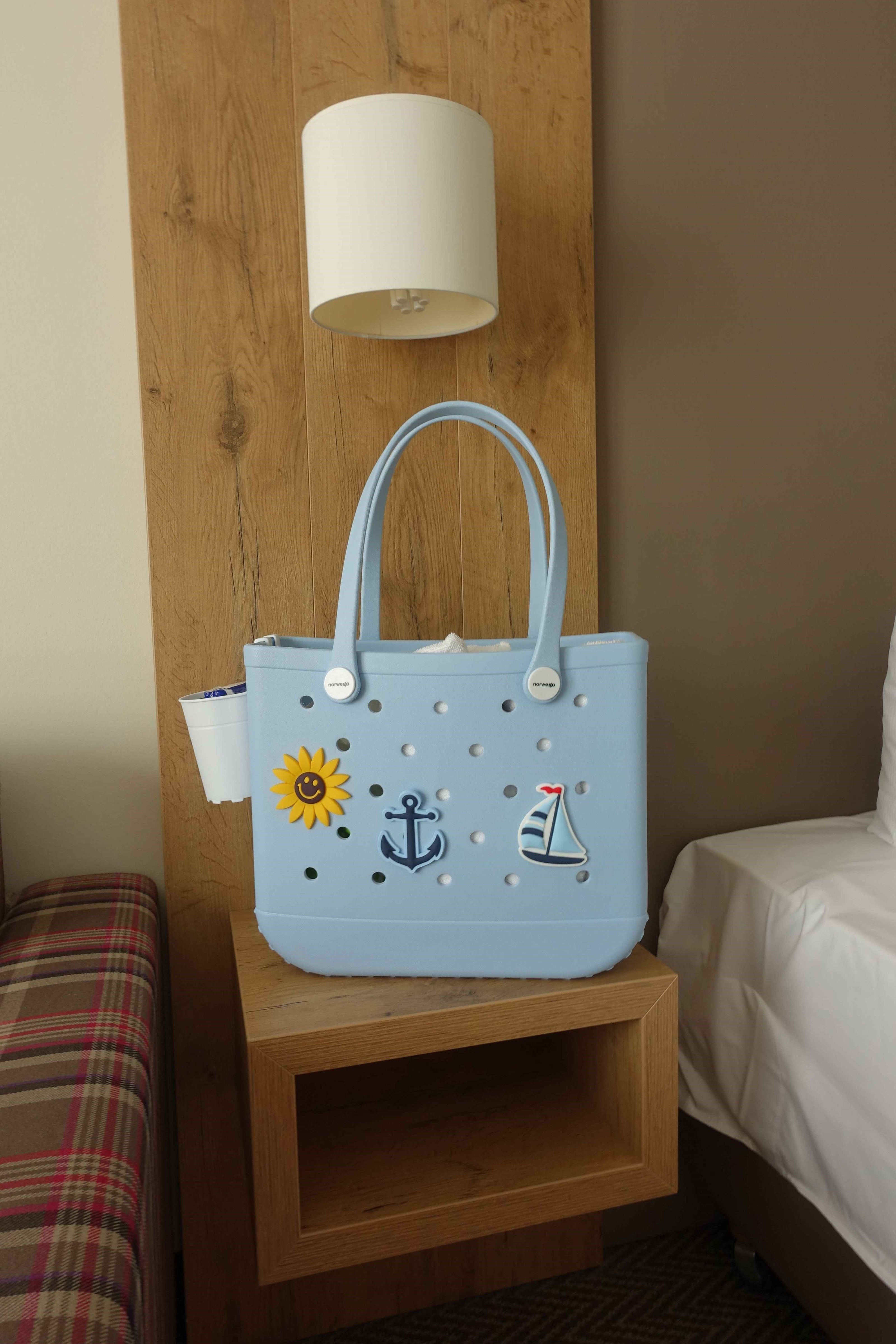 Blaue Tasche in Größe M, fotografiert von einem Kunden auf einem Hotelzimmer – stilvoller Begleiter für Reisen und Alltag.